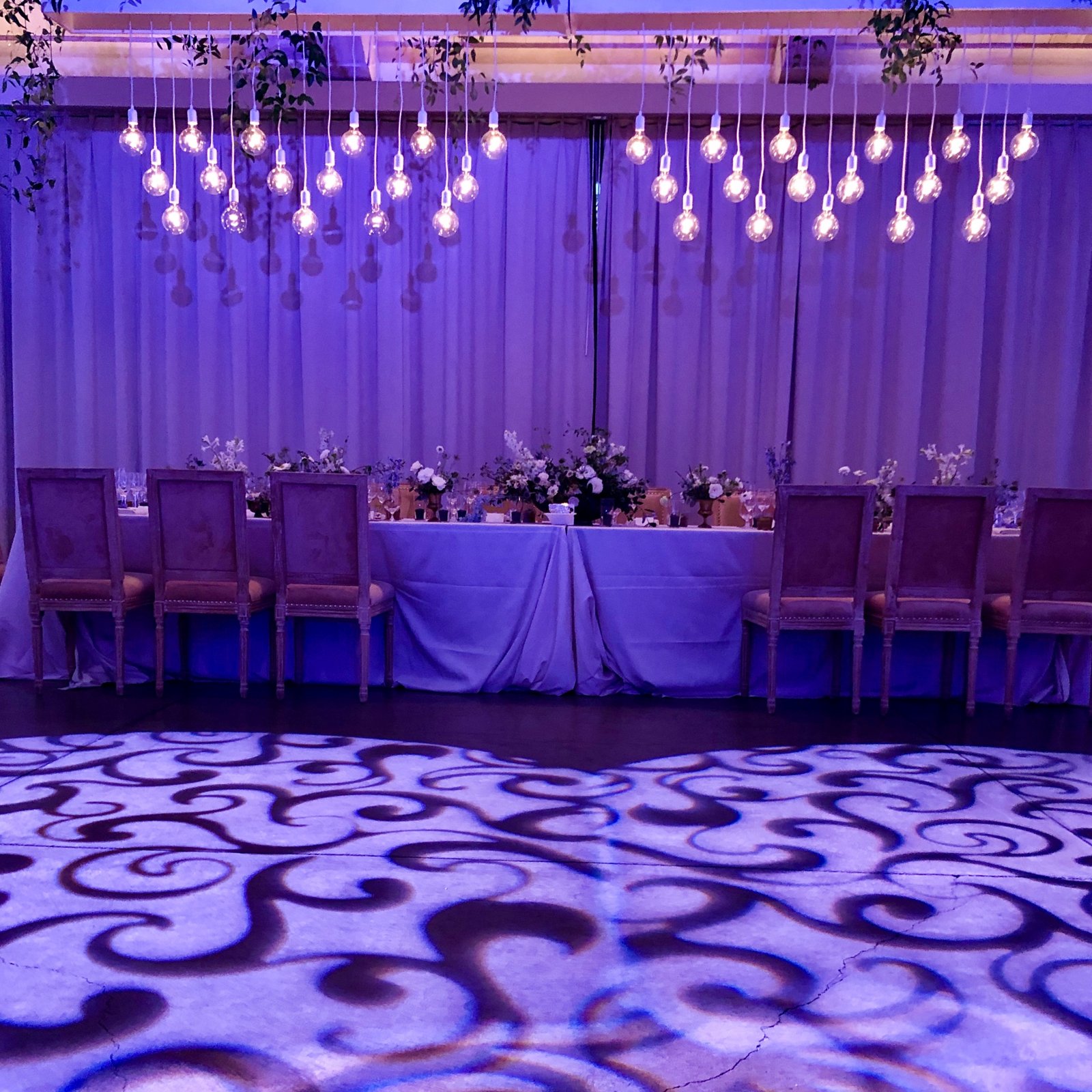 Wedding dance floor with custom pattern lighting in front of the head table, set up by W Square Event Production