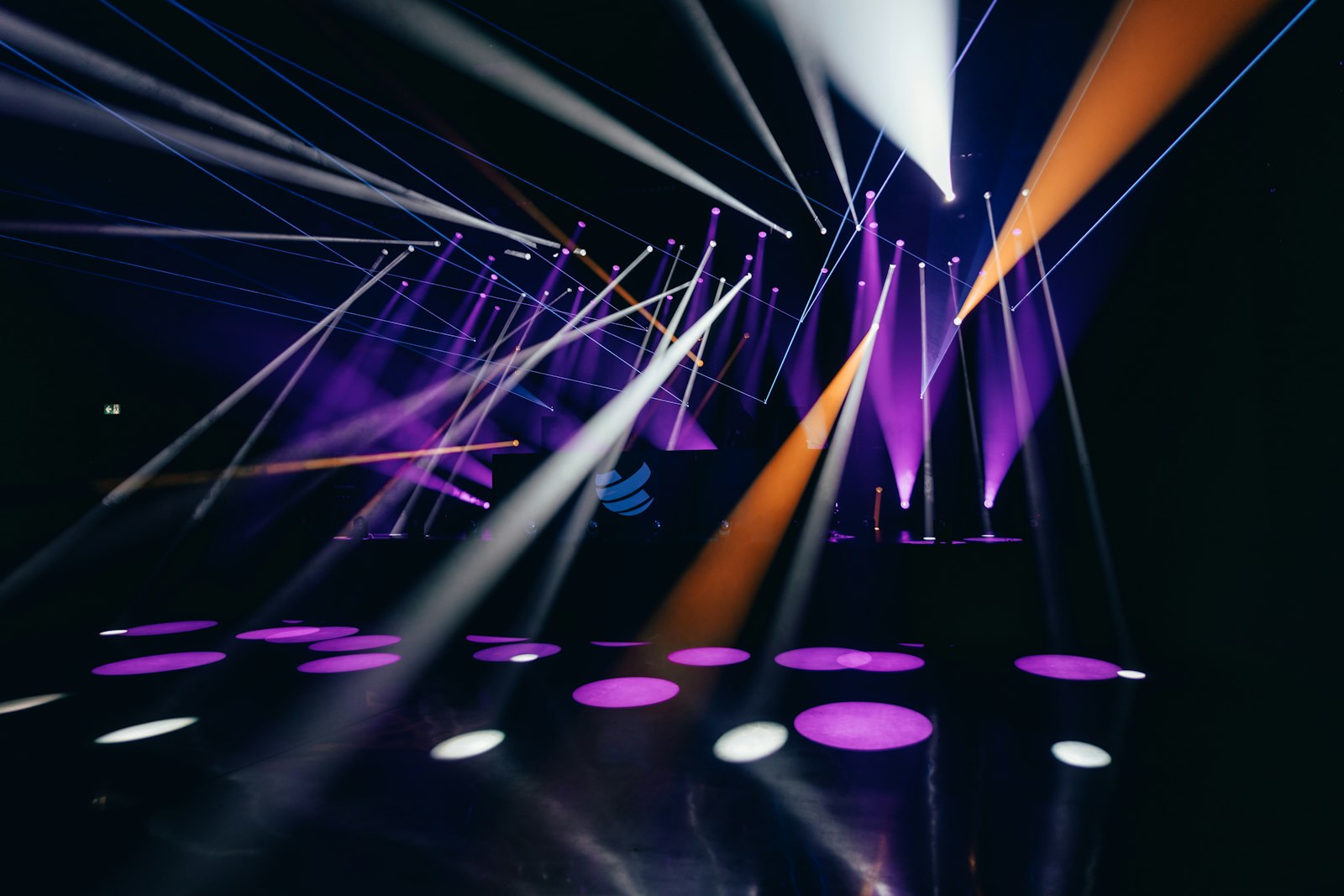 Moving beams and colored spots across a dark dance floor
